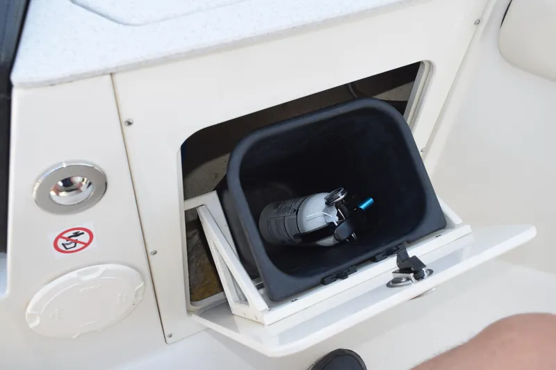 Slide: The Image of Storage compartment on 2021 Stingray 236CC boat with fire extinguisher inside. - 14