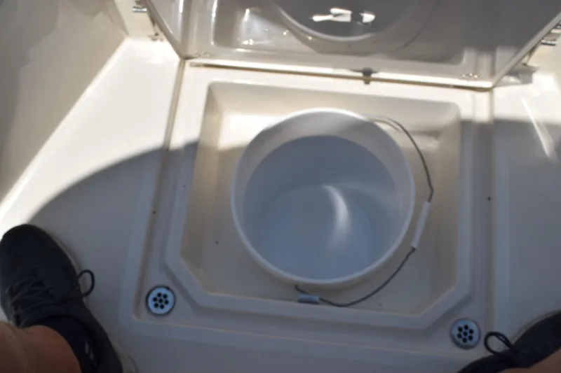 Slide: The Image of 2021 Stingray 236CC boat interior with open storage compartment and bucket. - 16