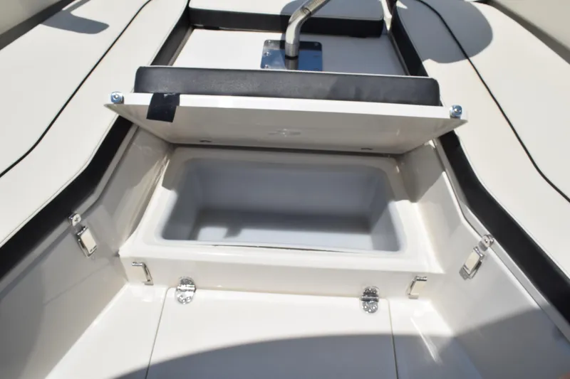 Slide: The Image of 2021 Stingray 236CC boat storage compartment with open lid, showcasing interior space. - 17