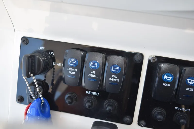 Slide: The Image of Control panel of a 2021 Stingray 236CC boat with various switches and key ignition. - 24