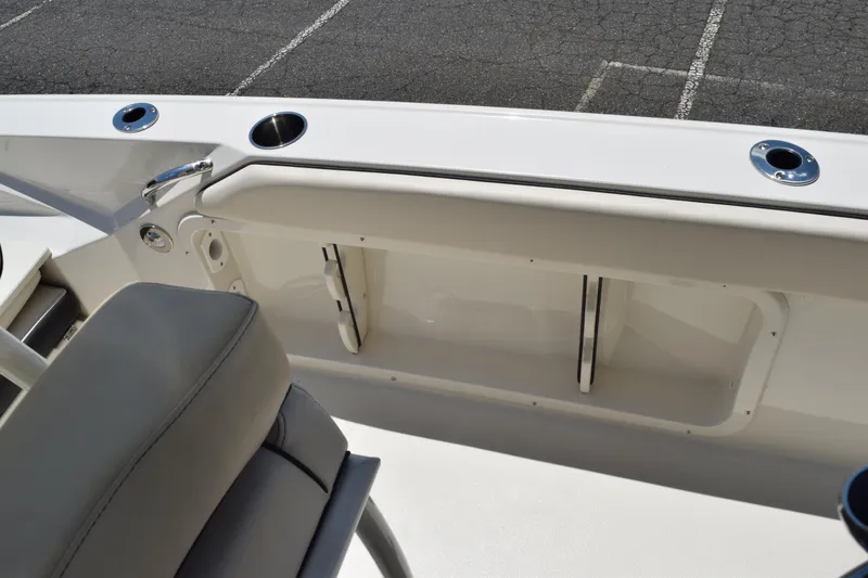 Slide: The Image of 2021 Stingray 236CC boat interior with storage compartment and cup holders. - 36