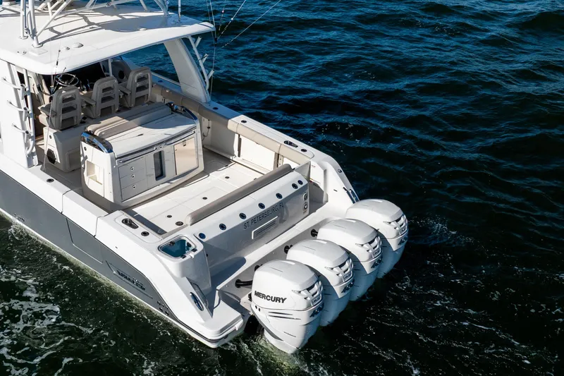 Slide: The Image of 2021 Boston Whaler 420 Outrage with triple Mercury engines cruising on open water. - 10