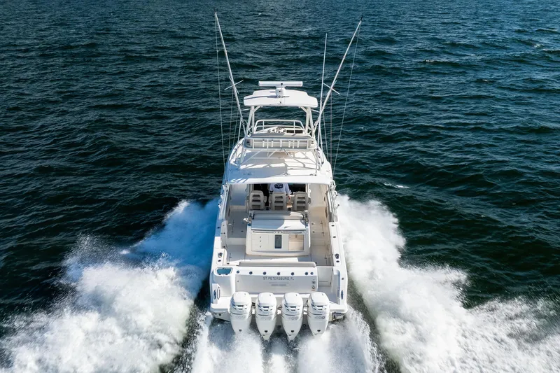 Slide: The Image of 2021 Boston Whaler 420 Outrage cruising on open water, rear view. - 14