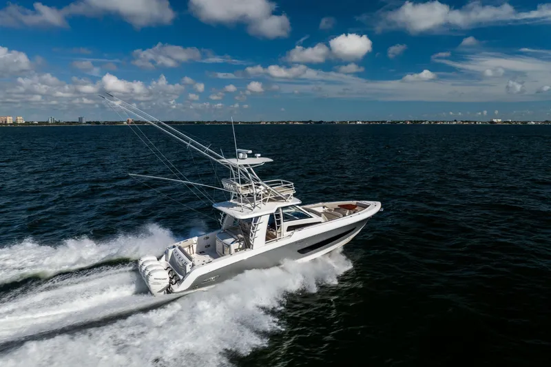 Slide: The Image of 2021 Boston Whaler 420 Outrage cruising on open water under a blue sky. - 18