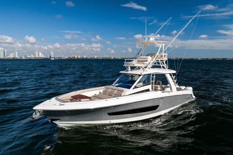 Slide: The Image of 2021 Boston Whaler 420 Outrage cruising on open water under clear blue skies. - 2
