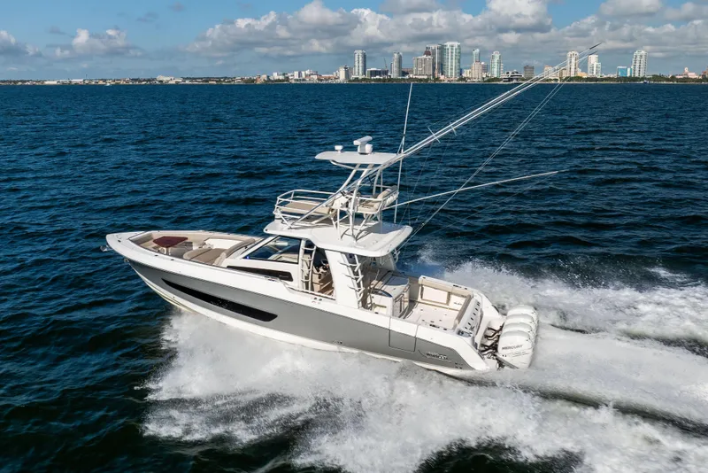 Slide: The Image of 2021 Boston Whaler 420 Outrage cruising on ocean with city skyline in background. - 20
