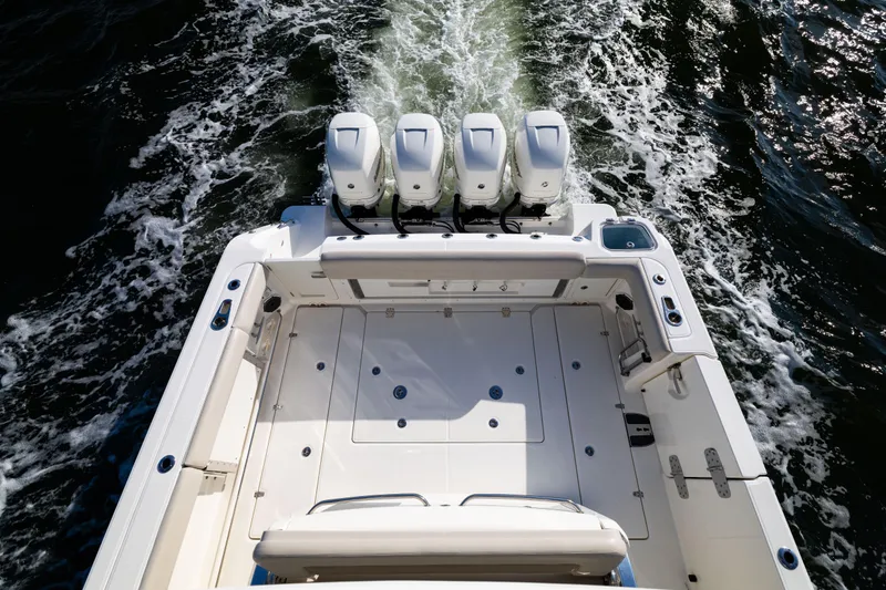 Slide: The Image of 2021 Boston Whaler 420 Outrage boat with four engines cruising on water. - 23