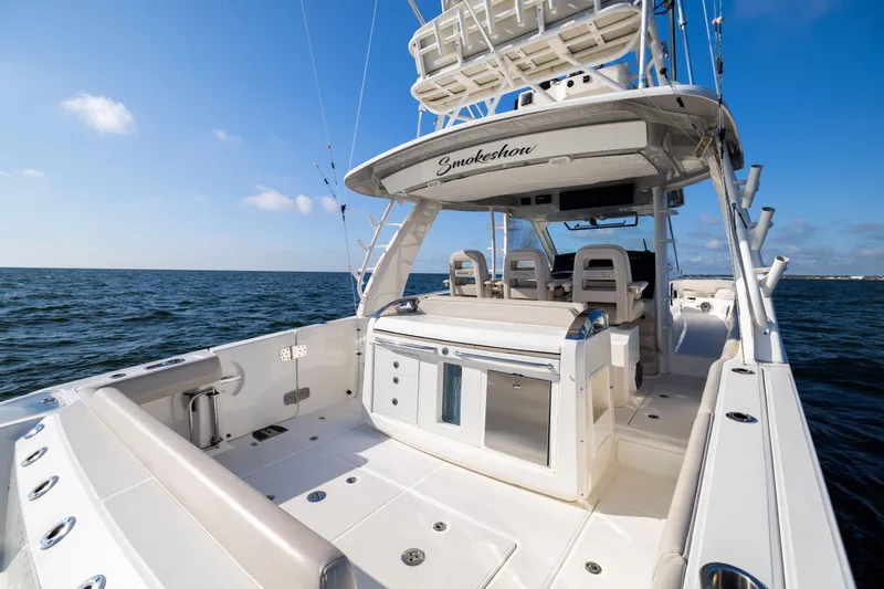 Slide: The Image of 2021 Boston Whaler 420 Outrage boat on open water, featuring spacious deck and seating. - 28