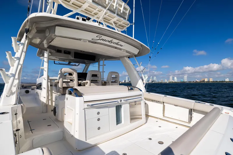 Slide: The Image of 2021 Boston Whaler 420 Outrage boat on water, city skyline in background, clear blue sky. - 29