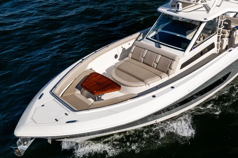 Slide: The Image of 2021 Boston Whaler 420 Outrage cruising on water, showcasing luxury seating and sleek design. - 3