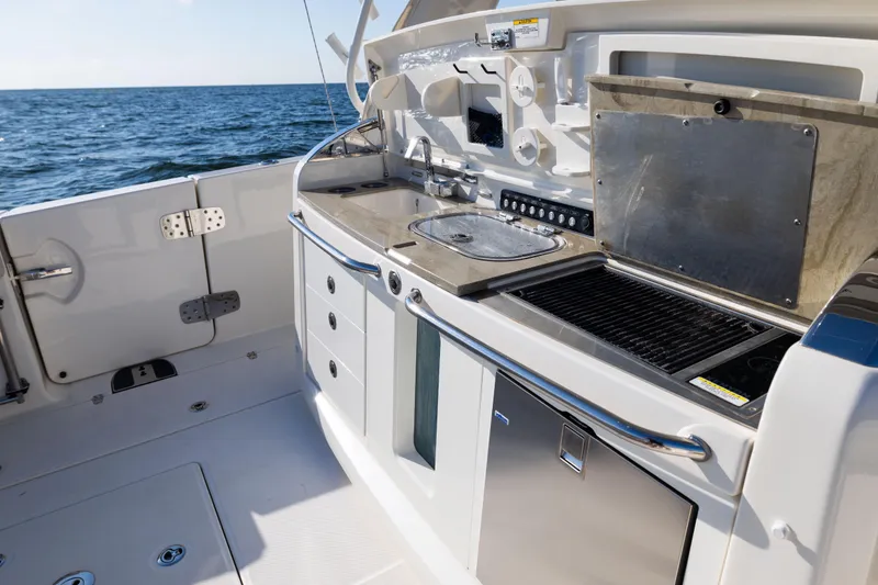 Slide: The Image of 2021 Boston Whaler 420 Outrage boat kitchen with grill and sink, ocean view. - 32