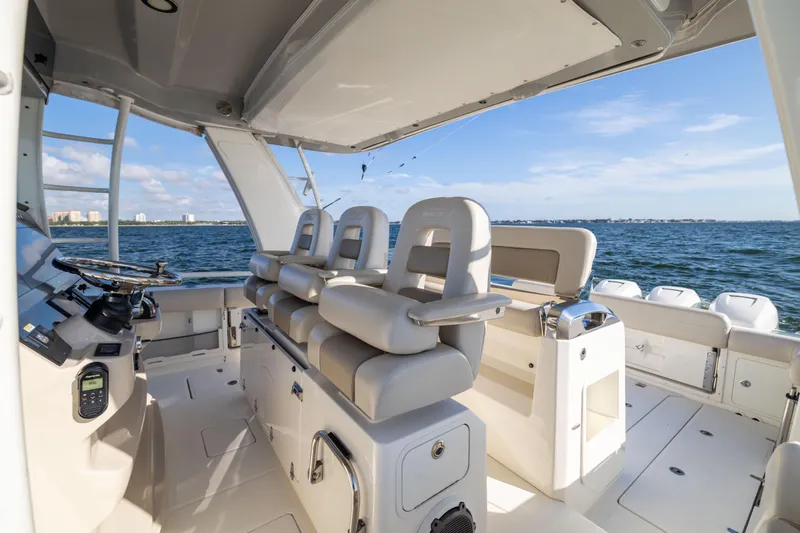 Slide: The Image of 2021 Boston Whaler 420 Outrage boat interior with helm and seating, ocean view. - 49