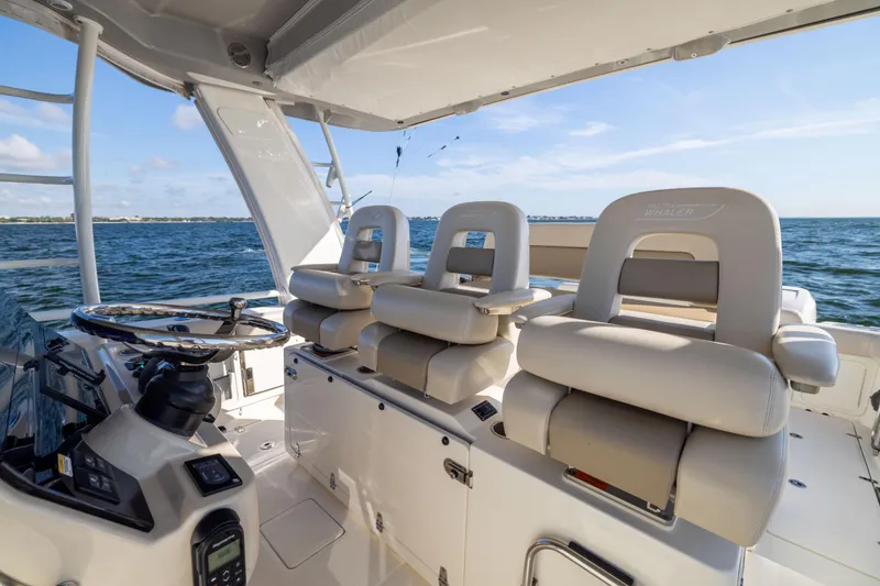 Slide: The Image of 2021 Boston Whaler 420 Outrage helm with luxurious seating and ocean view. - 50