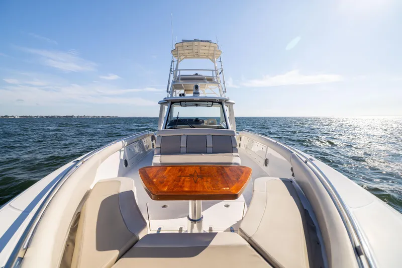 Slide: The Image of 2021 Boston Whaler 420 Outrage cruising on open water, featuring spacious deck and seating. - 67