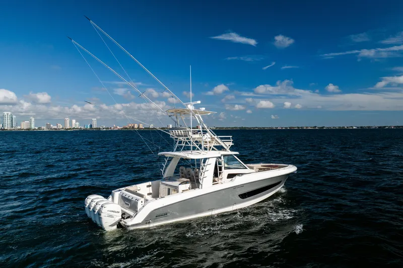 Slide: The Image of 2021 Boston Whaler 420 Outrage cruising on open water with city skyline in background. - 9