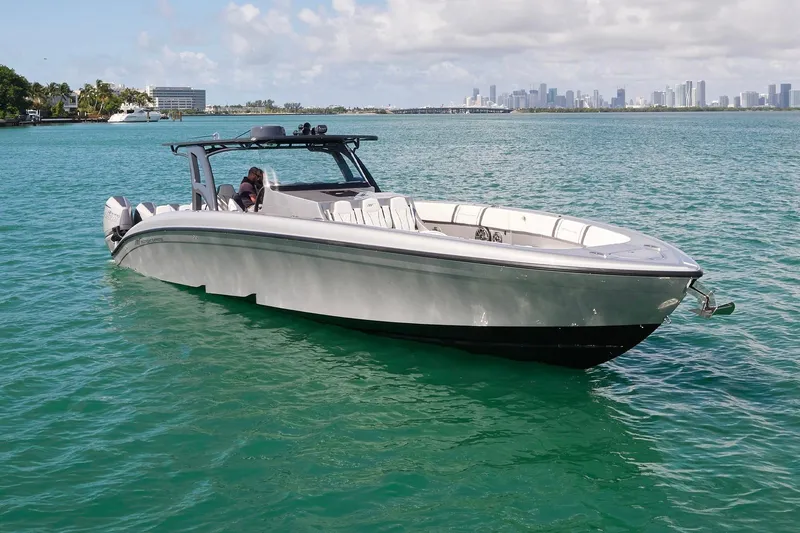 Slide: The Image of 2022 Midnight Express 43 Open boat on turquoise water with city skyline in background. - 12