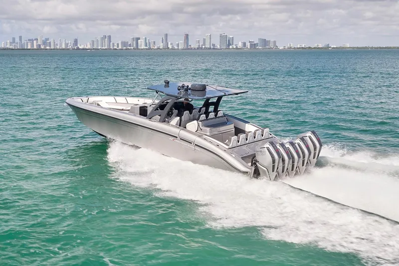 Slide: The Image of 2022 Midnight Express 43 Open boat cruising on turquoise water with city skyline backdrop. - 9