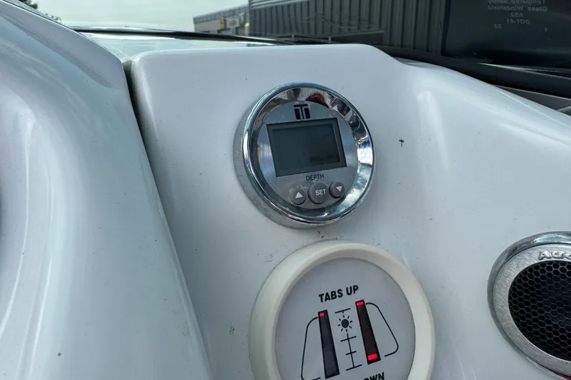 Slide: The Image of Control panel of a 2004 Baja 275 boat with depth gauge and tab controls. - 11