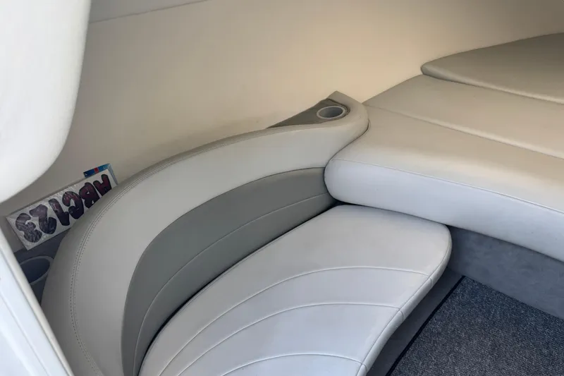 Slide: The Image of 2004 Baja 275 boat interior with white leather seating and cup holder. - 15