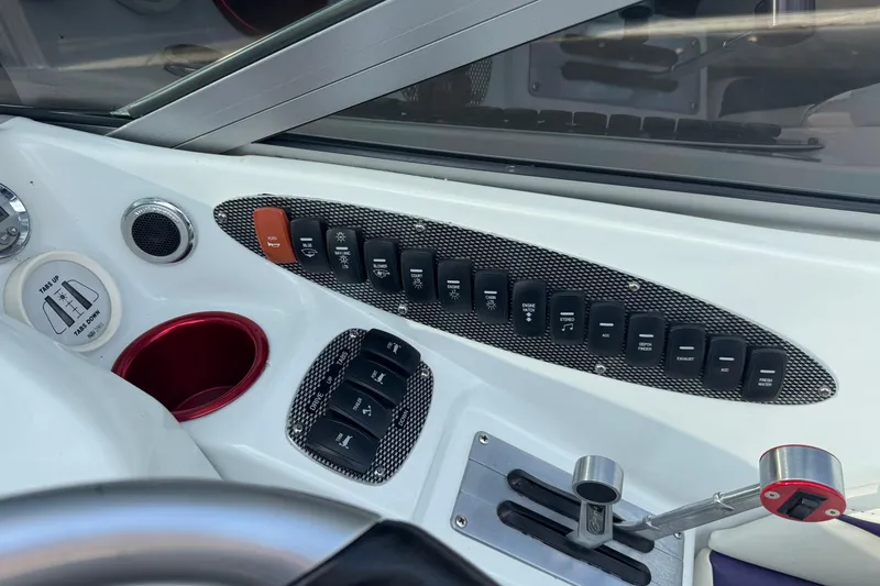 Slide: The Image of Dashboard of a 2004 Baja 275 boat with control switches and throttle. - 20