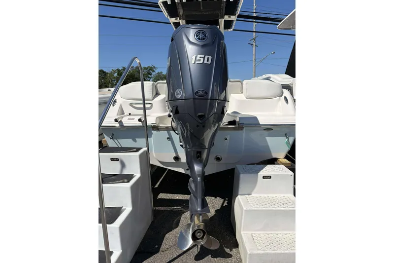 Slide: The Image of 2024 Key West 203 FS boat with Yamaha 150 outboard motor, docked with steps. - 15