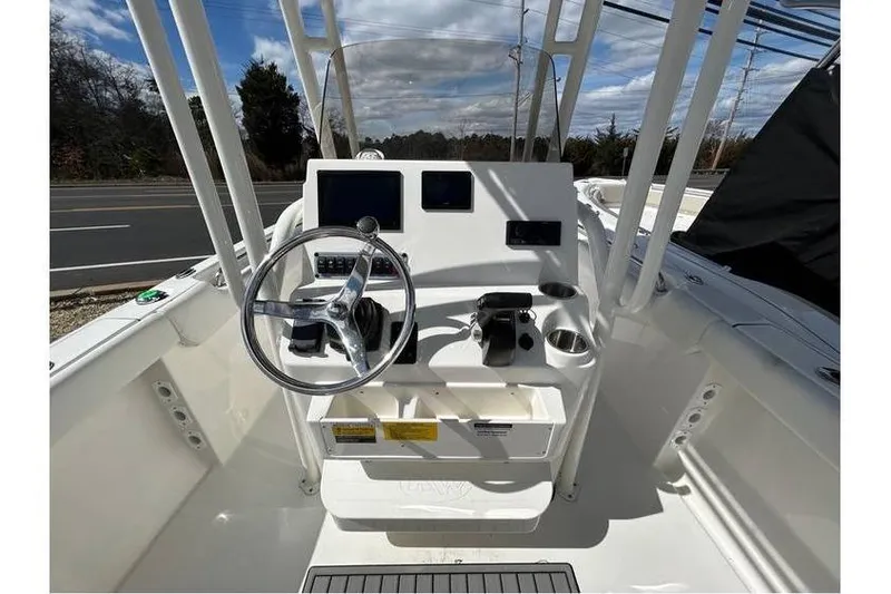 Slide: The Image of 2024 Key West 203 FS boat console with steering wheel and controls. - 2