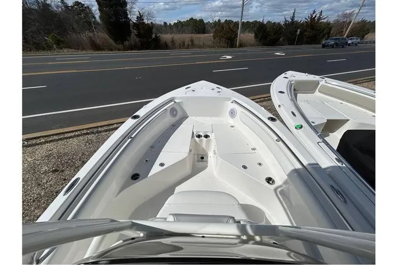Slide: The Image of 2024 Key West 203 FS boat, white interior, parked near a road, clear sky background. - 4