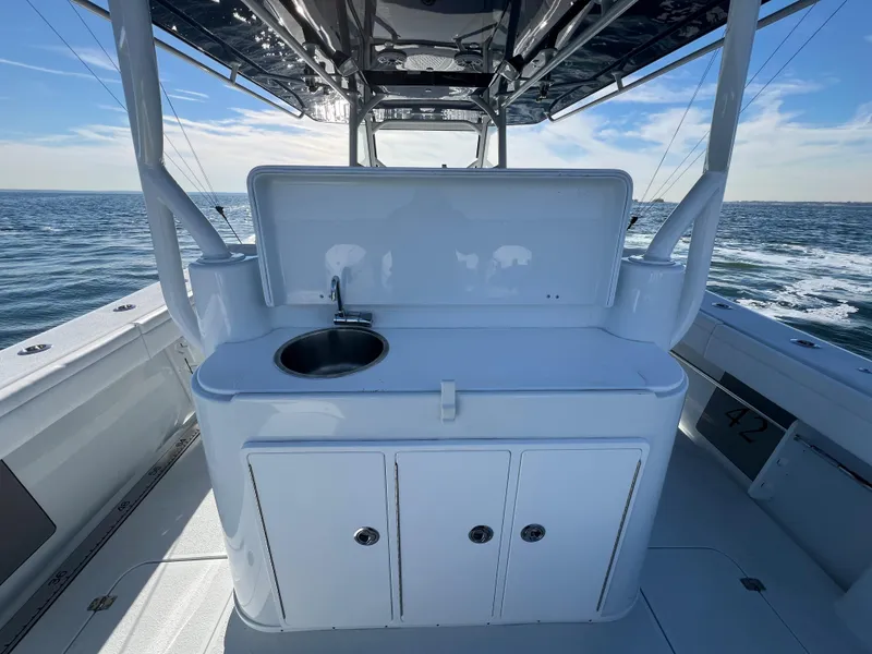 Slide: The Image of 2023 Yellowfin 42 Offshore boat with sink and storage, ocean backdrop. - 12