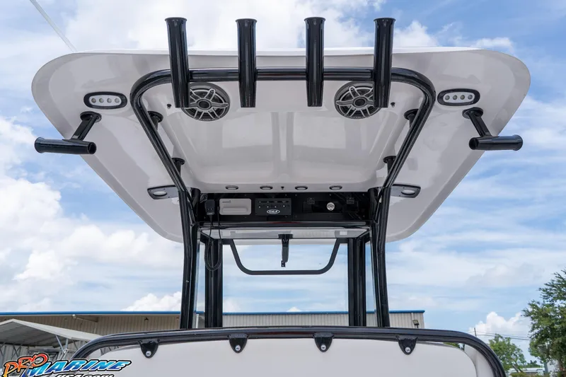 Slide: The Image of 2026 Sea Hunt Gamefish 27 Coffin Box T-top with rod holders and speakers, under blue sky. - 29