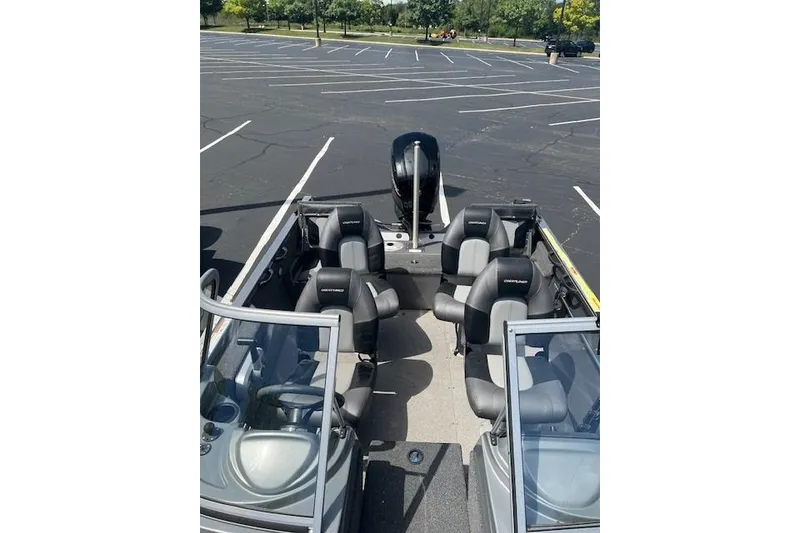 Slide: The Image of 2019 Crestliner 1700 Vision boat with seating, parked in an empty lot. - 3