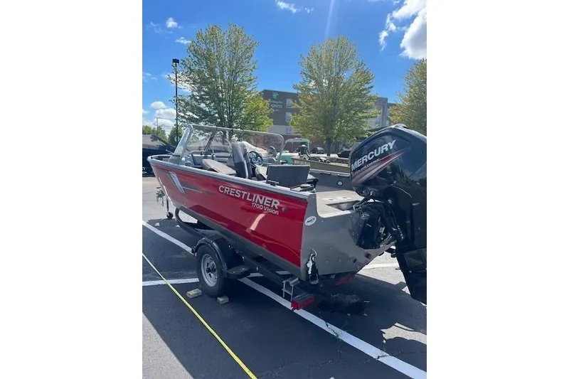 Slide: The Image of 2019 Crestliner 1700 Vision boat with Mercury engine on trailer, parked outdoors. - 4