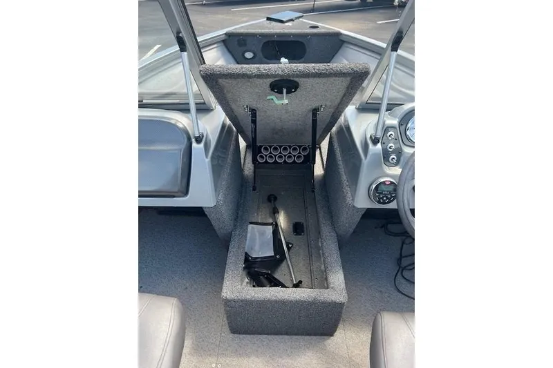 Slide: The Image of 2019 Crestliner 1700 Vision boat interior with open storage compartment and dashboard view. - 6