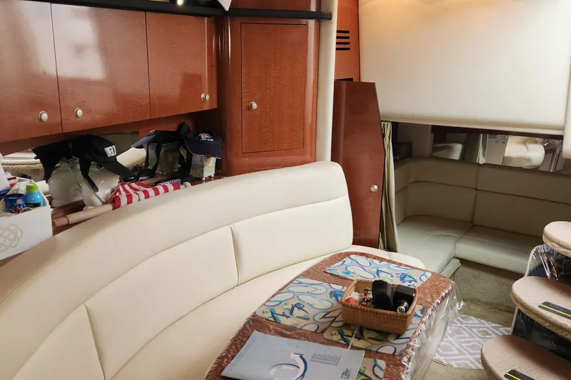 Slide: The Image of Interior of 2005 Sea Ray 320 Sundancer with beige seating and wooden cabinetry. - 10
