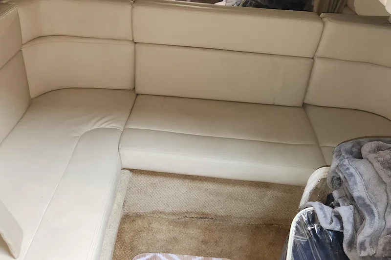 Slide: The Image of 2005 Sea Ray 320 Sundancer interior with beige leather seating and carpeted flooring. - 11