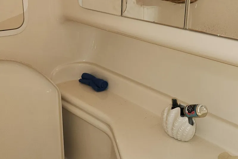 Slide: The Image of 2005 Sea Ray 320 Sundancer bathroom with mirror, shelf, and toiletries. - 12