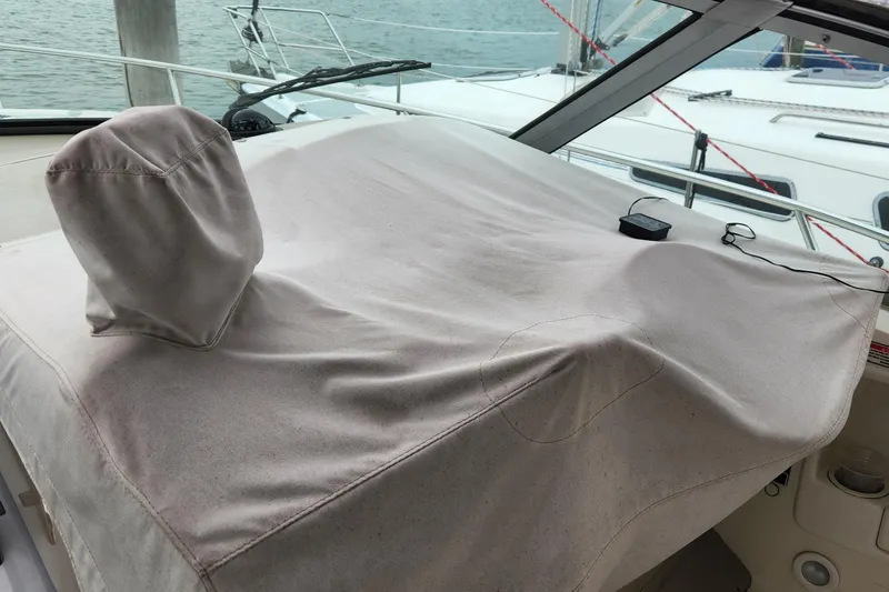 Slide: The Image of 2005 Sea Ray 320 Sundancer helm covered, docked near other boats. - 6