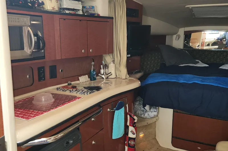 Slide: The Image of Interior of 2005 Sea Ray 320 Sundancer with kitchenette and cozy sleeping area. - 8
