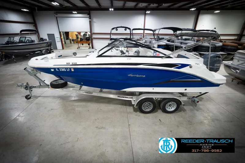 The Image of 2022 Hurricane 235RD boat in showroom, blue and white design, on trailer. - 1