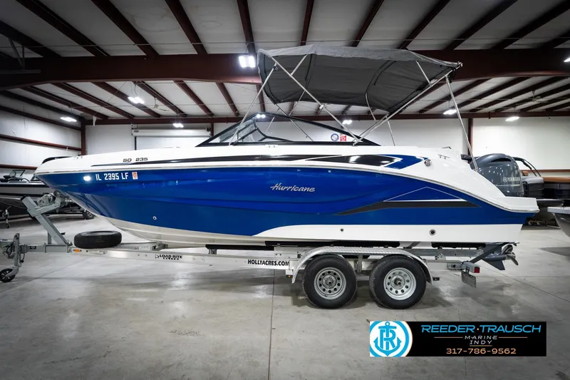 Slide: The Image of 2022 Hurricane 235RD boat in showroom, blue and white design, on trailer. - 10