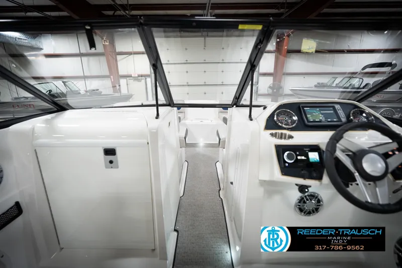 Slide: The Image of 2022 Hurricane 235RD boat interior with modern dashboard and steering wheel in showroom. - 16