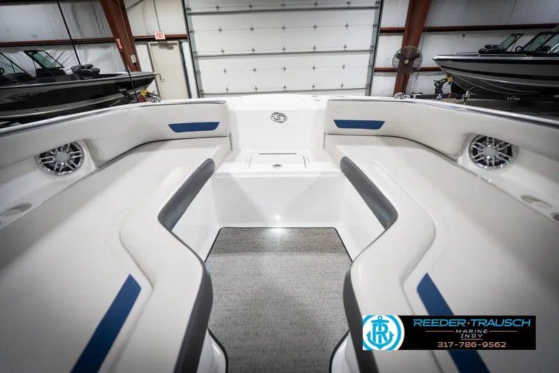 Slide: The Image of 2022 Hurricane 235RD boat interior with white seating and blue accents in a showroom. - 17