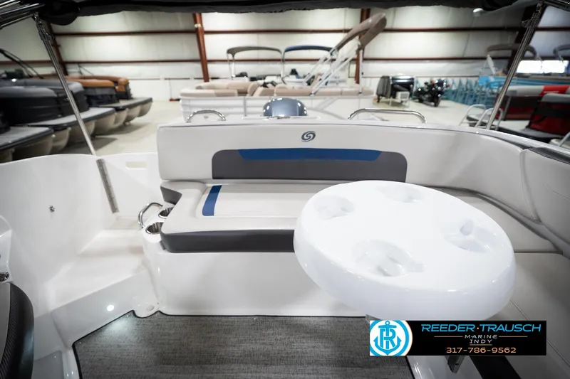 Slide: The Image of 2022 Hurricane 235RD boat interior with seating and table, displayed in a showroom. - 20