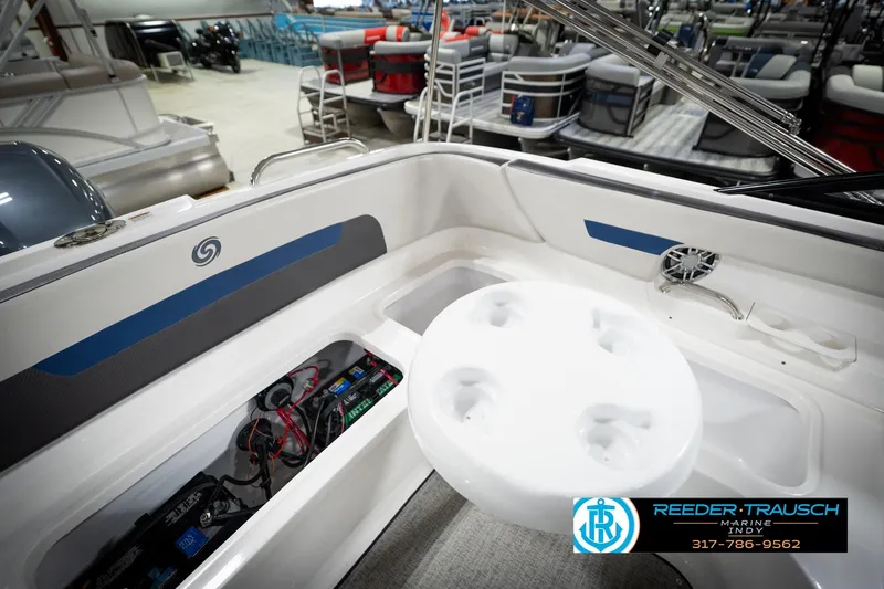 Slide: The Image of 2022 Hurricane 235RD boat interior with seating, storage, and cup holders in showroom. - 22