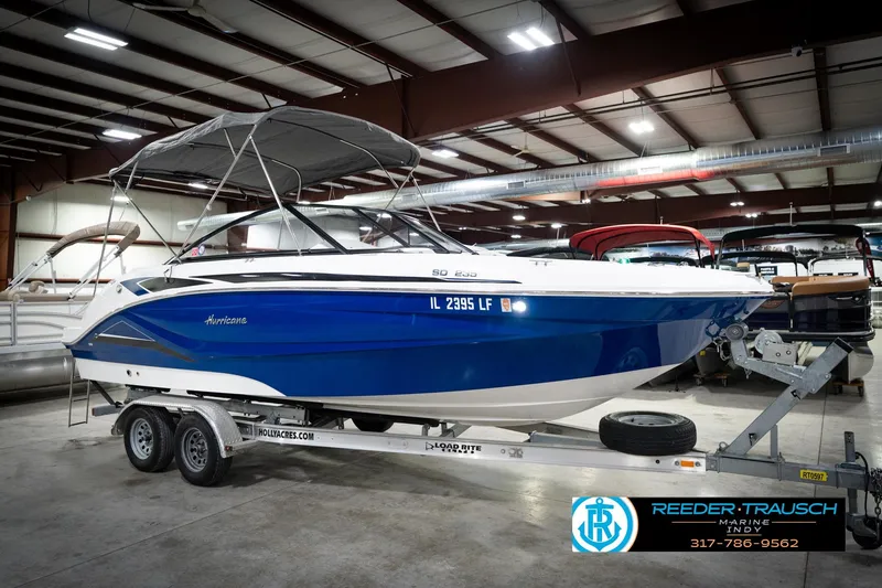 Slide: The Image of 2022 Hurricane 235RD boat on trailer in indoor showroom, blue and white design. - 5