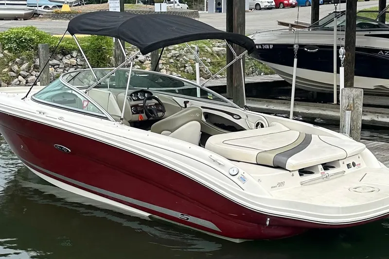 Slide: The Image of 2006 Sea Ray 220 Select boat with red hull and black canopy docked in marina. - 5