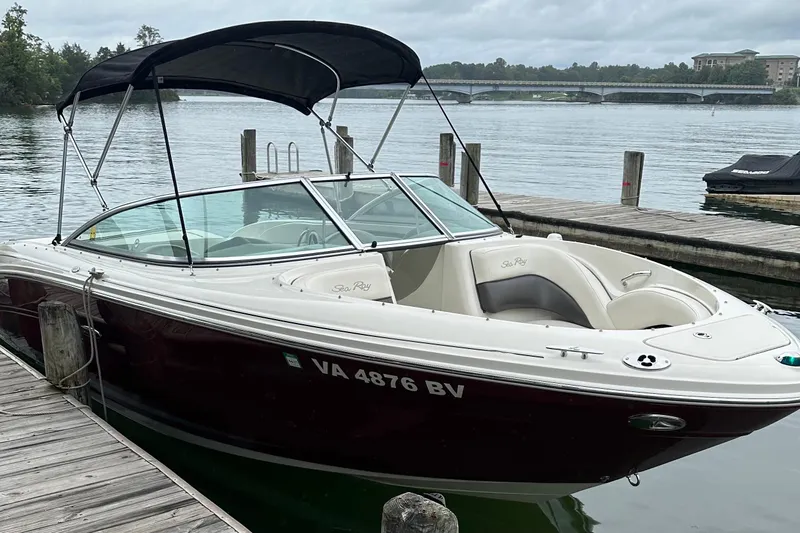 Slide: The Image of 2006 Sea Ray 220 Select boat docked by a serene lake with overcast skies. - 9