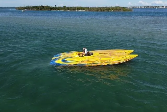 The Image of Yellow MTI 40RP speedboat on water, 2007 model, with vibrant flame design. - 0