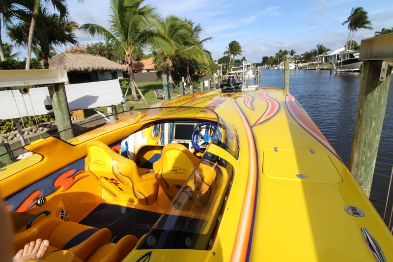 Slide: The Image of Bright yellow 2007 MTI 40RP speedboat with vibrant interior, docked by a tropical canal. - 11