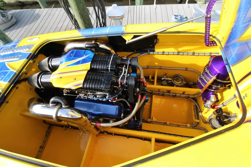 Slide: The Image of Engine compartment of a 2007 MTI 40RP boat, featuring vibrant yellow and blue accents. - 13