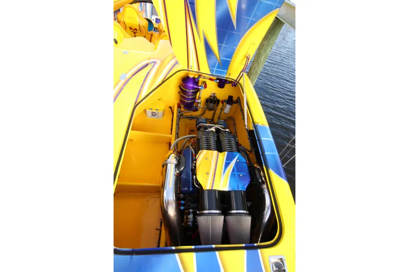 Slide: The Image of Engine compartment of a 2007 MTI 40RP boat with vibrant yellow and blue design. - 17